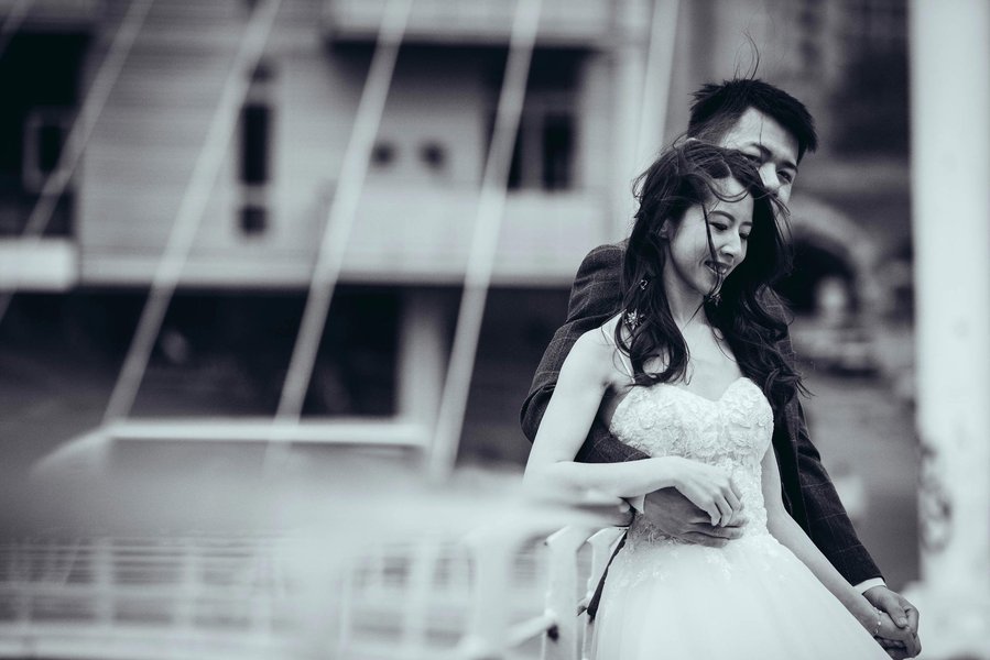 candid and natural wedding photography, city centre urban wedding, shot of couple posing on bridge with wind blowing brides hair