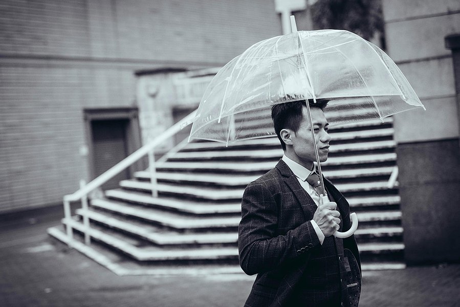 candid and natural wedding photography, city centre urban wedding, groom holding umbrella