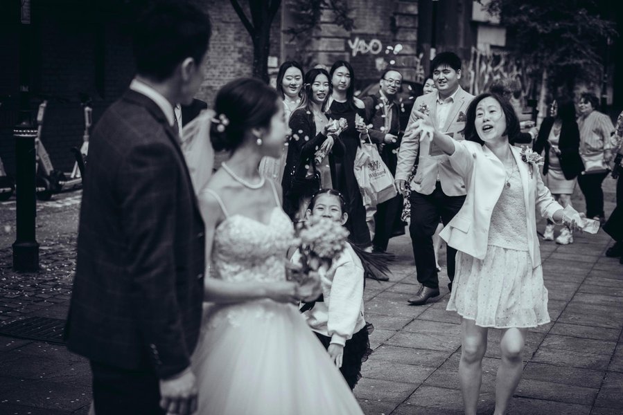 candid and natural wedding photography, city centre urban wedding, wedding couple laughing as confetti thrown at them by guests