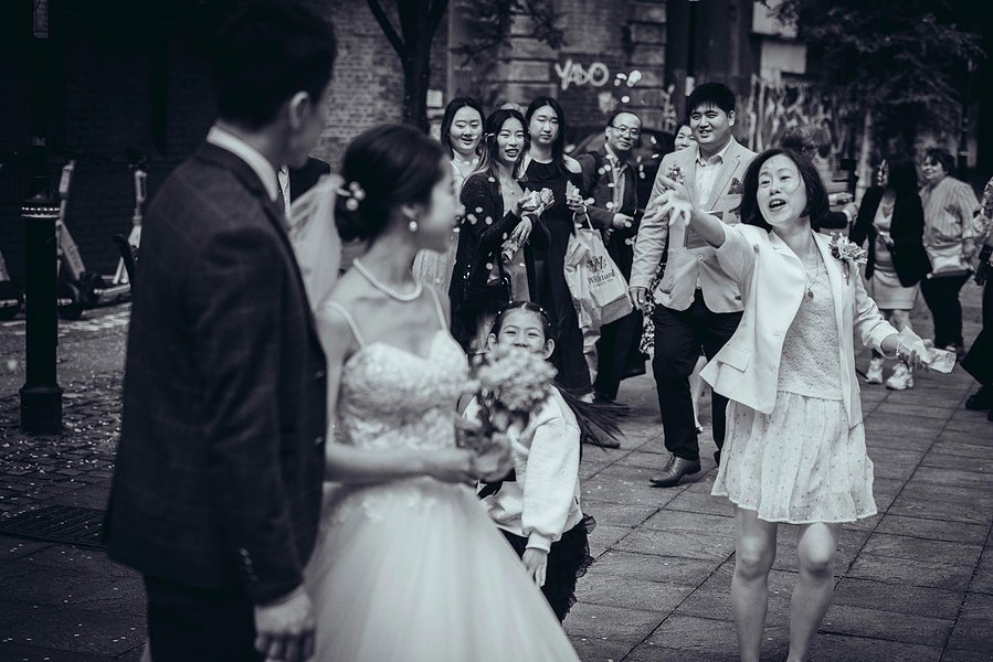 candid and natural wedding photography, city centre urban wedding, wedding couple laughing as confetti thrown at them by guests
