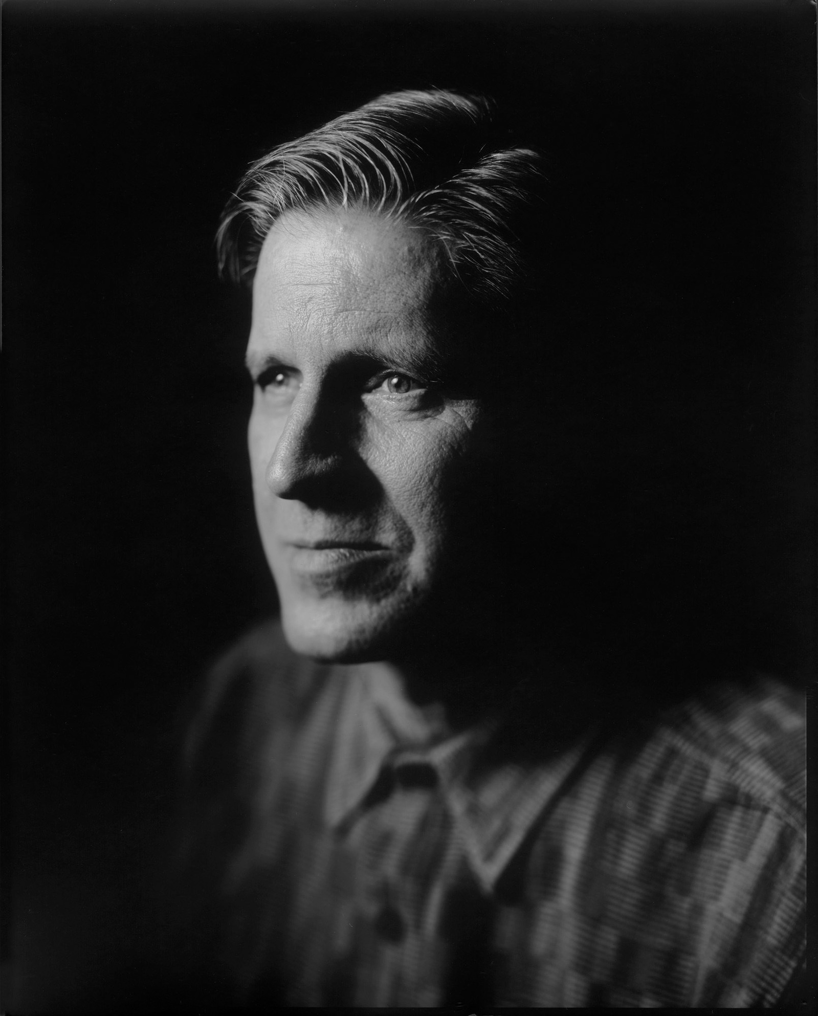 Large format paper negative portrait of a man in studio setting.