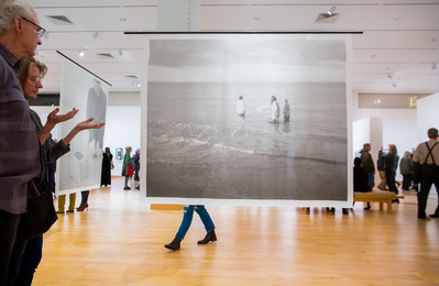 A piece of art is on display during an art opening at the Madison Museum of Contemporary Art in Madison, Wi. There is a crowd looking at art.   