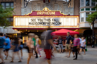 An evening at the Madison Night Market a crowd walks by the Orpheum sign.