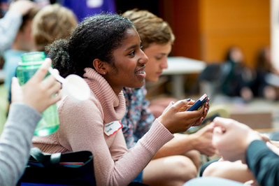 A young girl is listening or watching. You can decide. She looks good doing it. 