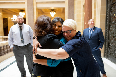 After a graduation held at the Wisconsin Capitol a group hugs to congratulate each other. 