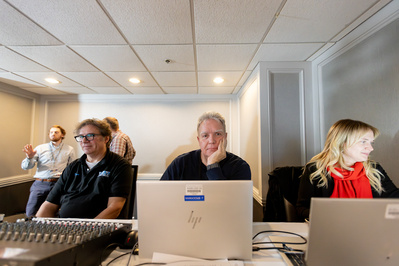Three behind the scenes people are working on computers to make an event happen at the Concourse Hotel in Madison, WI. 