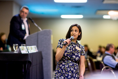 A business women is talking into a microphone. 