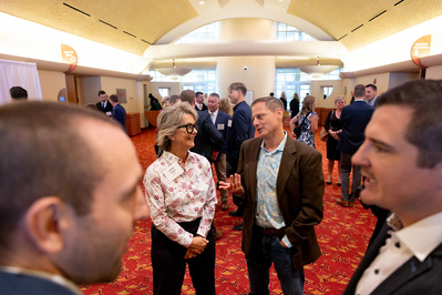 Two groups of people talking at a Greater Madison Chamber of Commerce event at the Monona Terrace in Madison, WI.