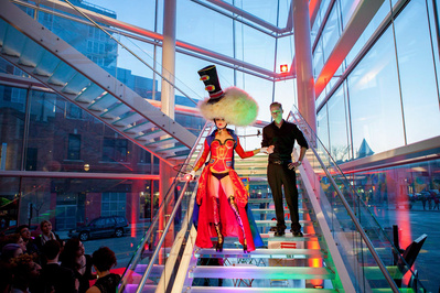 At an event at the Madison Museum of Contemporary Art a person with wild and fun hair walks down the stairs. 
