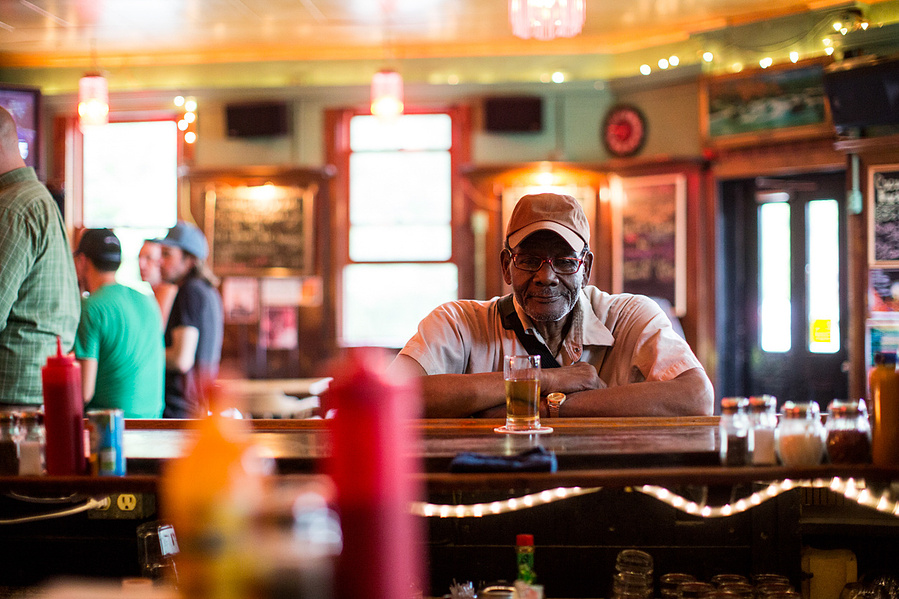 A man is sitting at the Mickeys bar in Madison, WI. 