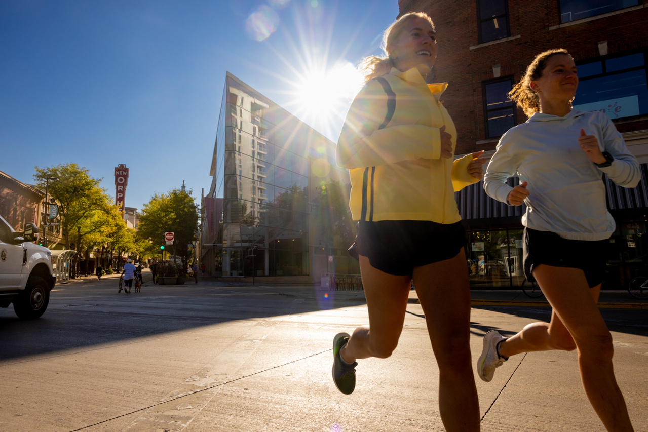 Active joggers enjoying State Street in Madison, Wisconsin. The sun shines behind the runners in the editorial photograph. Fitness photography for a magazine.