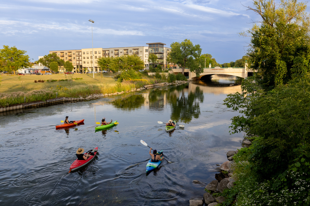 A panoramic photograph captures kayakers and canoeists along the Yahara River in Madison, WI.