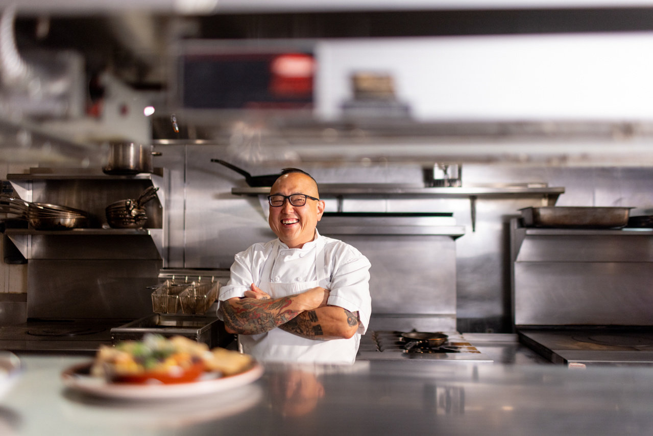 A candid portrait, commercial documentary photograph of Tory Miller, the Head Chef of L'Etoile and Graze.  The photographer captures the chef in his natural setting for a website placement.