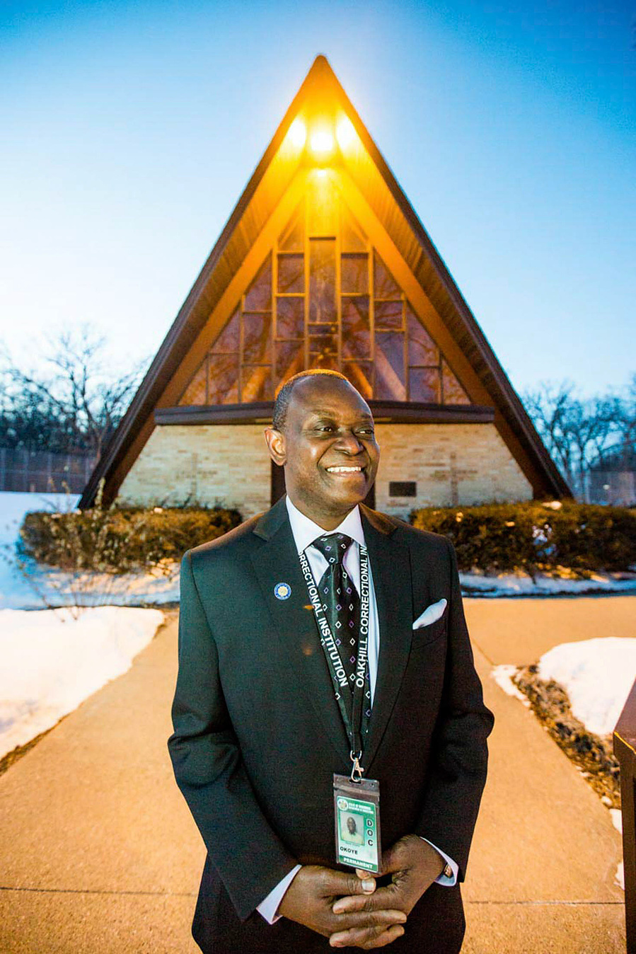 A chaplain stands outside his church. 