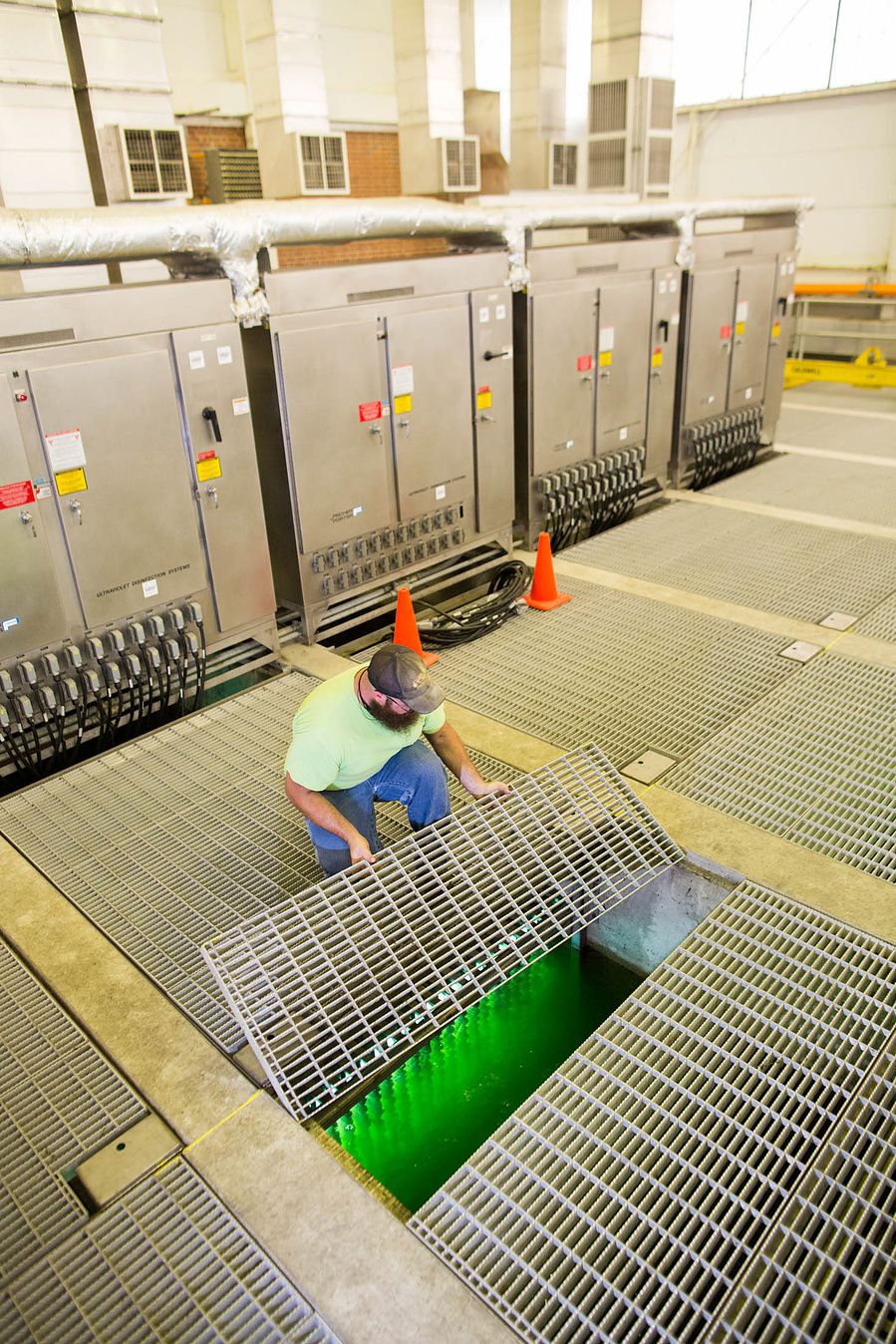 A worker at the Madison Metropolitan Sewerage District is opening a floor thing and it's bright green under there! It's wild! 