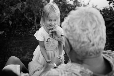 a smiling young girl enjoys time with her grandma in the family documentary photo