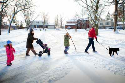 family photography in the winter with their pet in the snow.