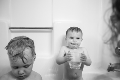 an artistic family photo of two siblings in the bath tub