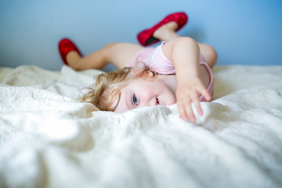 Baby photos! A toddler plays on their bed.