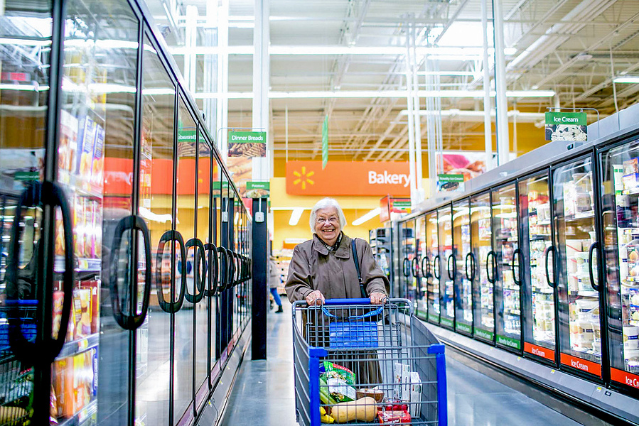 A smiling women shops at the walmart. 