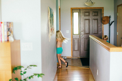 Family home photography, a child plays in the hallway of her home.