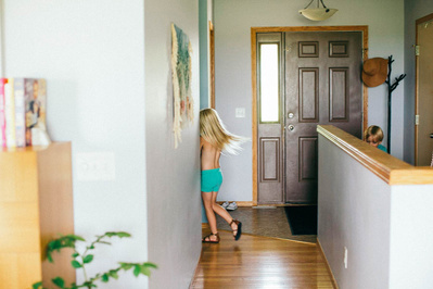 Family home photography, a child plays in the hallway of her home.