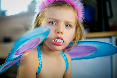 a young girl playing dress up using her imagination in this child portrait