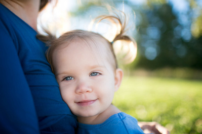 a content looking kid smiles while hugging their mother in this baby photo