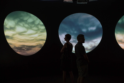 Art exhibit at the MMoCA. Two silouettes walk through circles that look like night skies. 