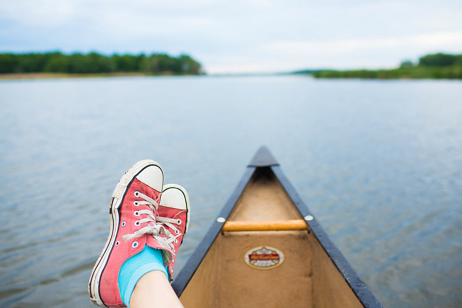 a pair of pink converse shoes rest on top of a canoe in the Cherokee Marsh. 