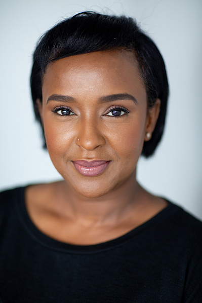 A beautiful black women lightly smiles at the camera. 