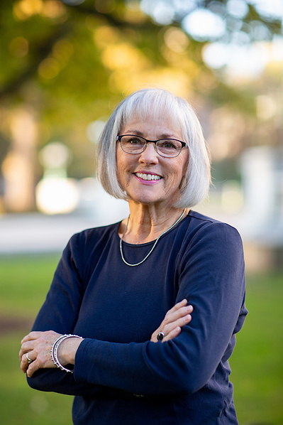 A women crosses her arms and smiles. 