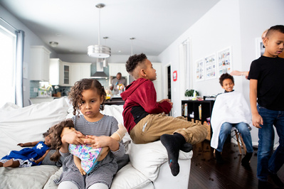 siblings gather in the living room of their house in this family documentary photo