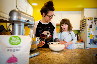 Family portrait realistic style a mother and daughter bake in their colorful kitchen.