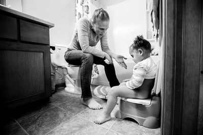 documentary family photo in black and white, a mother potty trains her daughter.