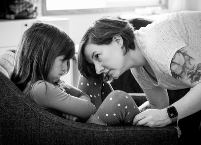 a mom and daughter share a serious moment in this candid family photo