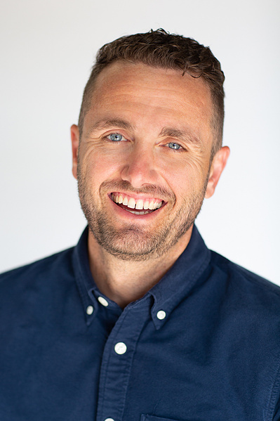 A man, with a fashionable front tooth gap, smiles. 
