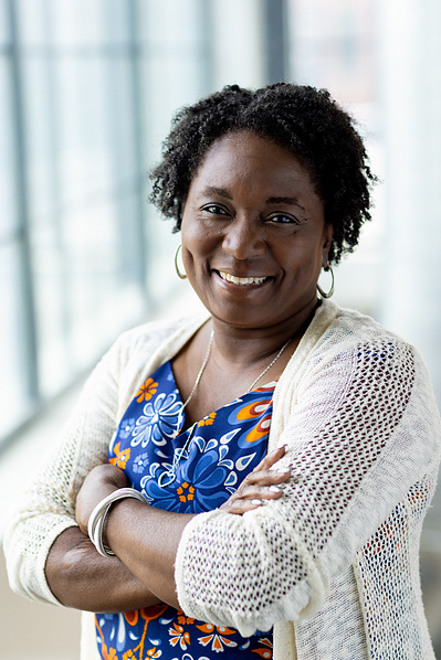 A women smiles with her arms crossed. 