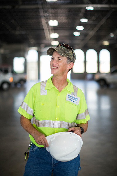 A women holds a hard hat. 