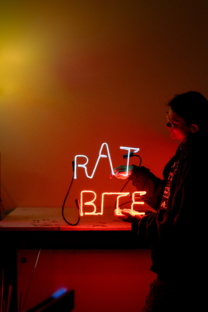 A student at the UW Madison neon class shows off their project that spells, "rat bit". This cracks me up. 