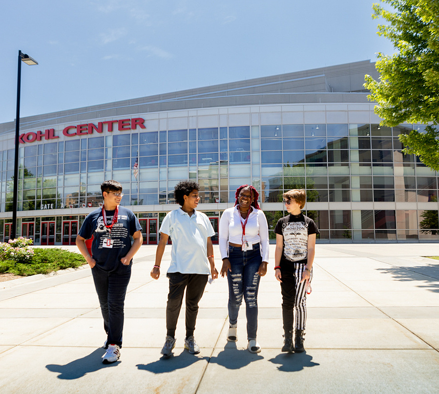 A group of kids are walking outside the Kohl Center on the UW Madison Campus, they are participating in the summer term program. 