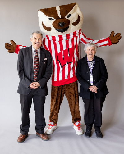 Bucky badger poses with 2 people at the University of Wisconsin. 