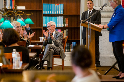 Tony Evers is clapping at an event at the Wisconsin Historial Society on the campus at the UW Madison. 
