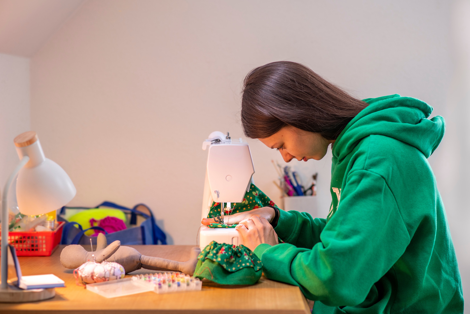 Junges Mädchen beim Nähen an der Nähmaschine – authentischer Moment voller Fokus und Kreativität. Niederösterreich, Tulln, Krems an der Donau