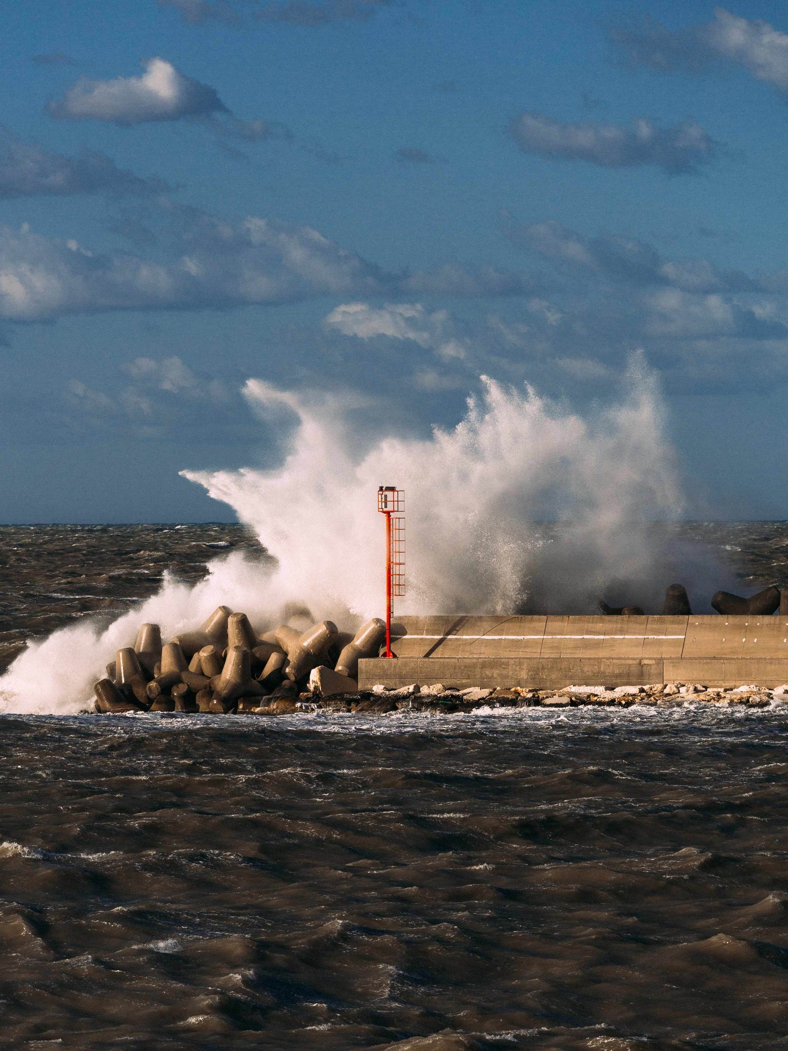 a wave crash on the harbor in a windy day