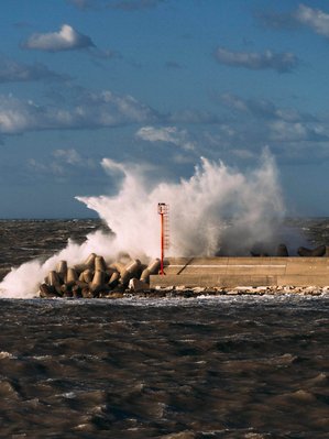 a wave crash on the harbor in a windy day
