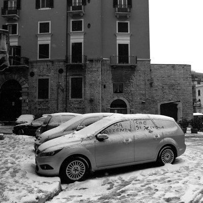 black and white photo of cars covered by snow in Bisceglie