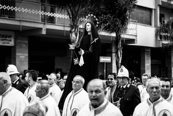 black and white photo of men carrying a statue of Mary