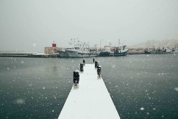bridge in Bisceglie's harbor covered by snow