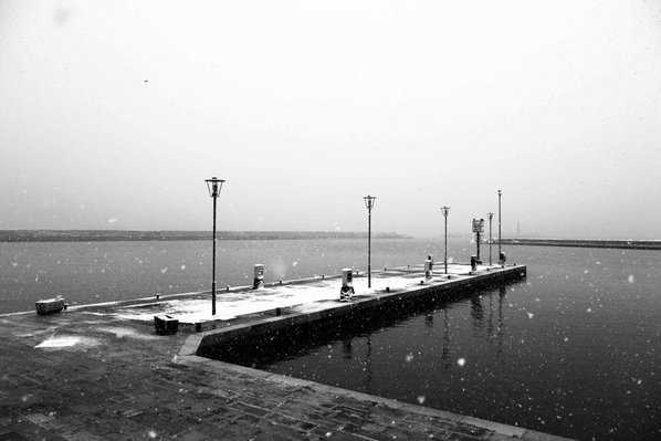 bridge in Bisceglie's harbor covered by snow